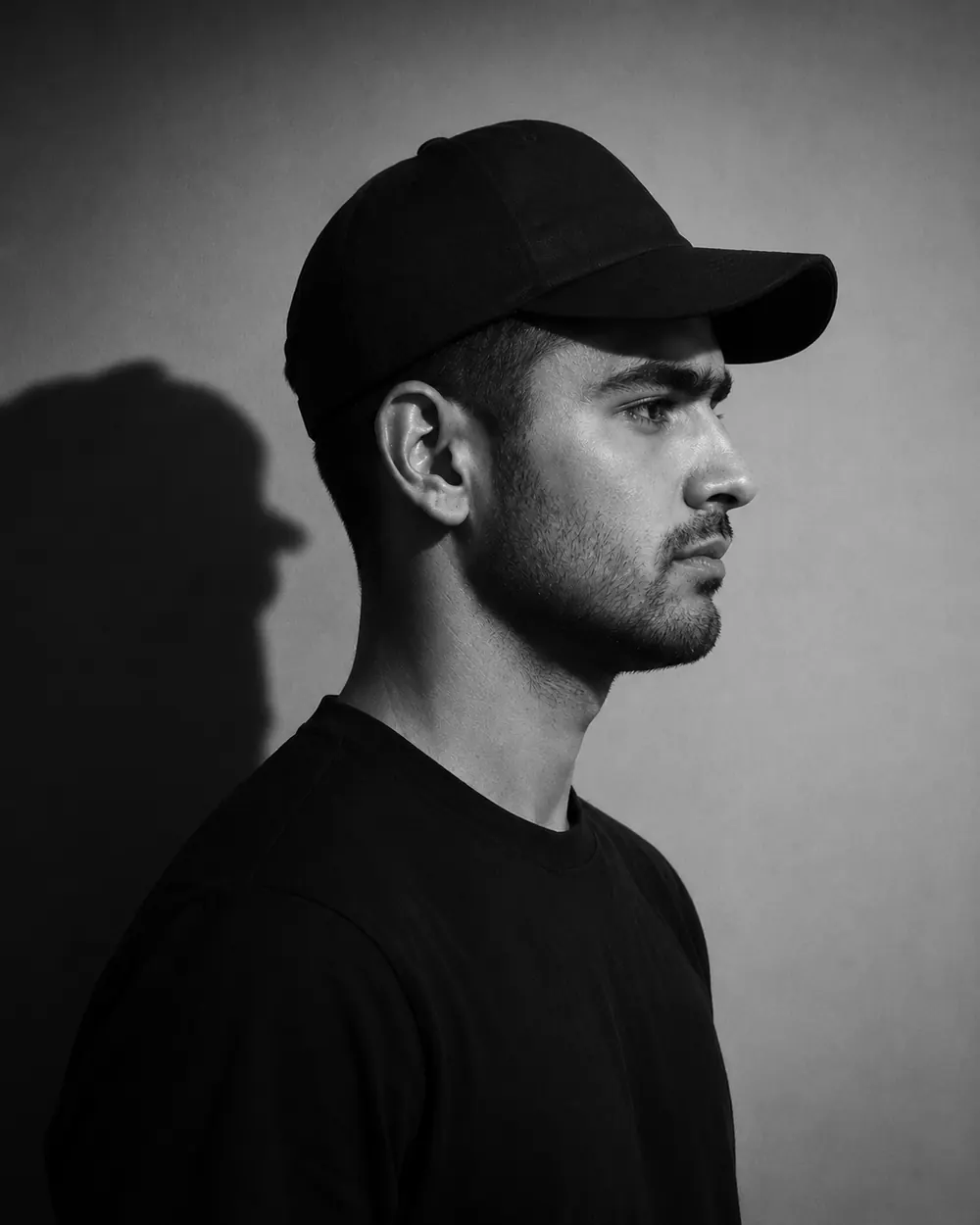 Black and white studio portrait of the Pehchan founder in profile, wearing a cap